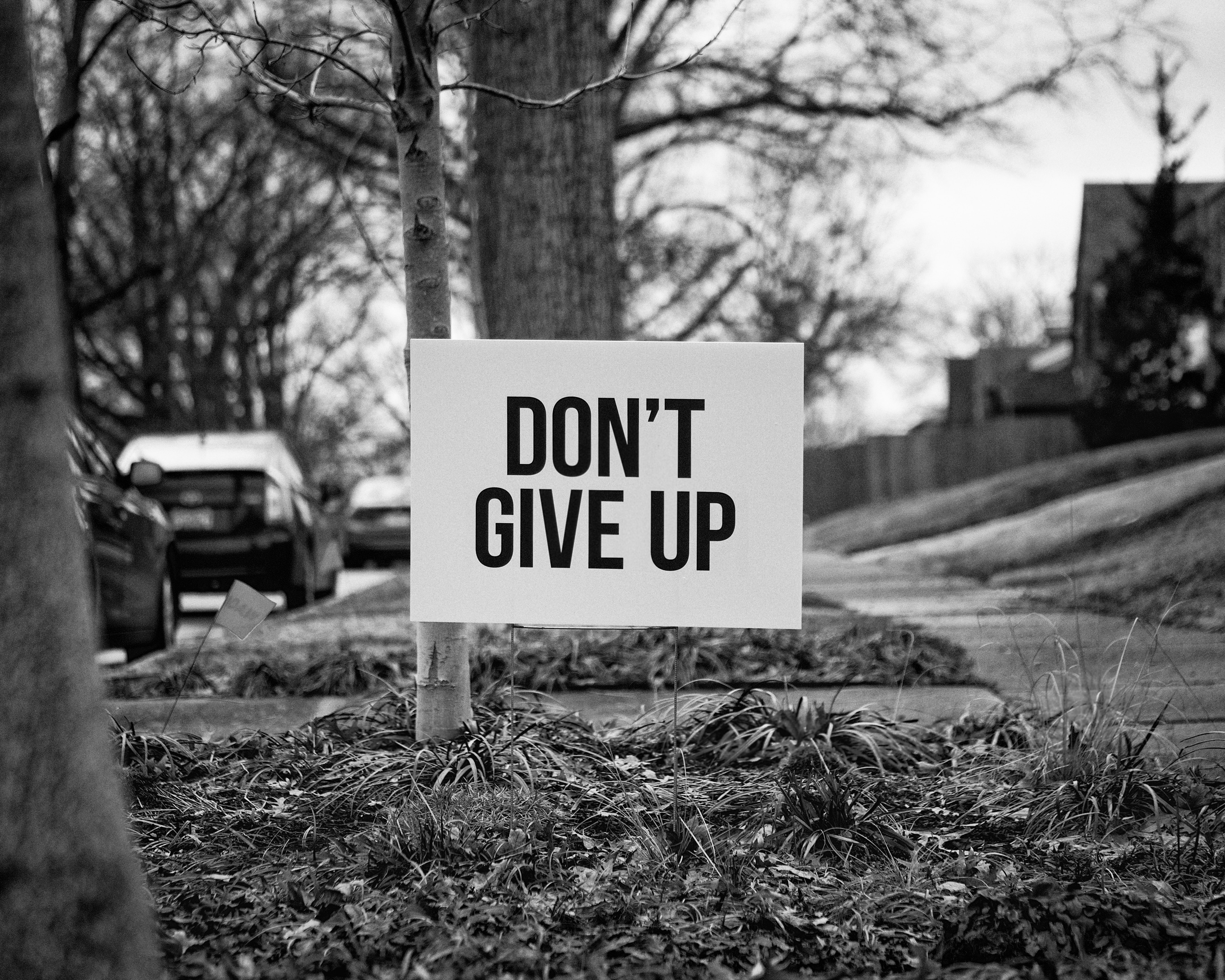  A sign next to a road saying “Don’t give up”